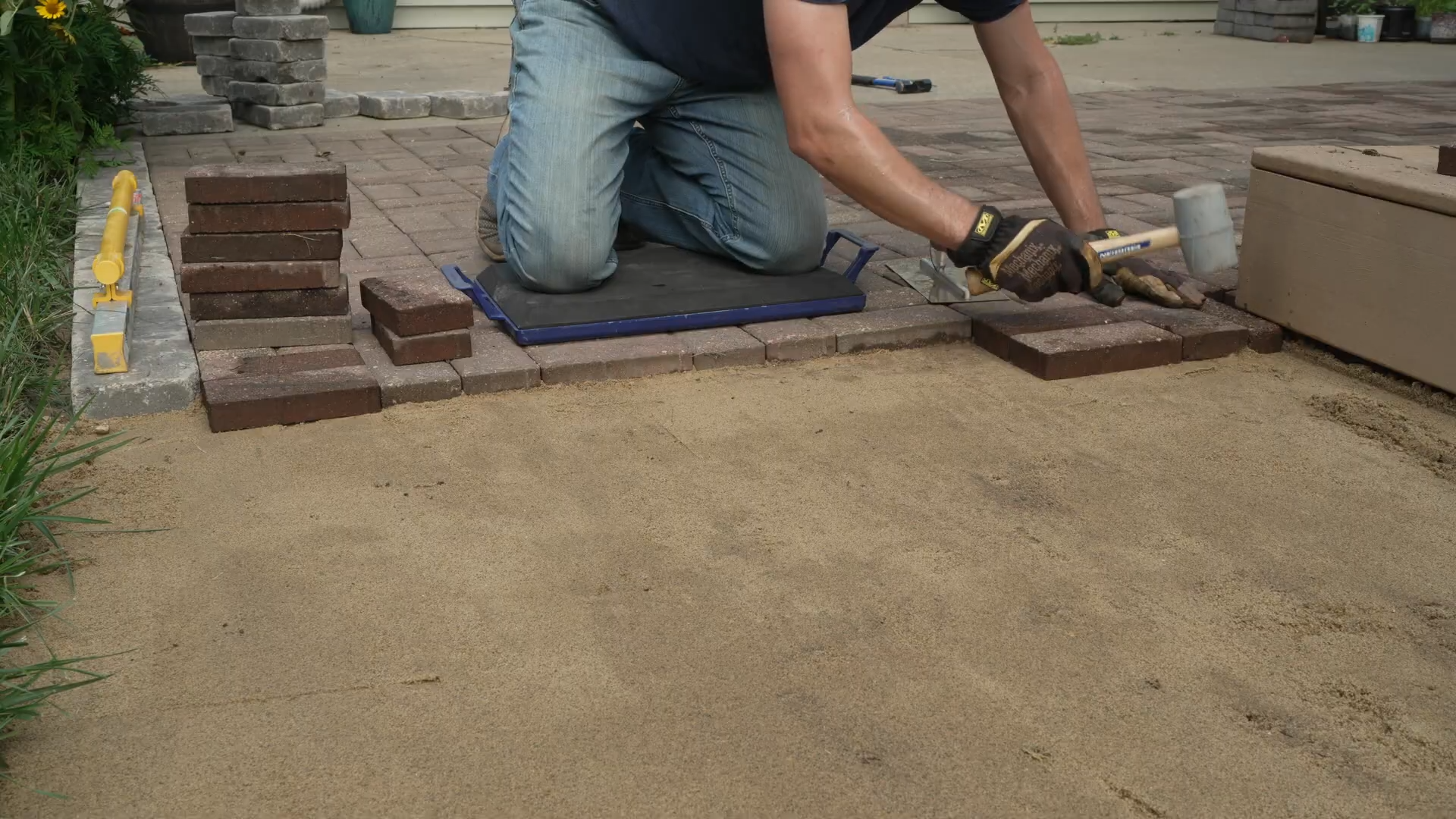 man using Vaughan Rubber Mallet to secure pavers into place